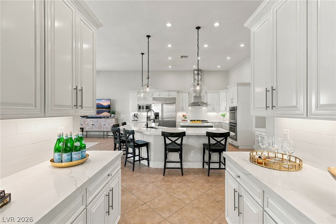 210 Torrey Morgan Way, Henderson, NV 89074 Recessed lighting and custom cabinetry frame a view into the kitchen from the wet bar.