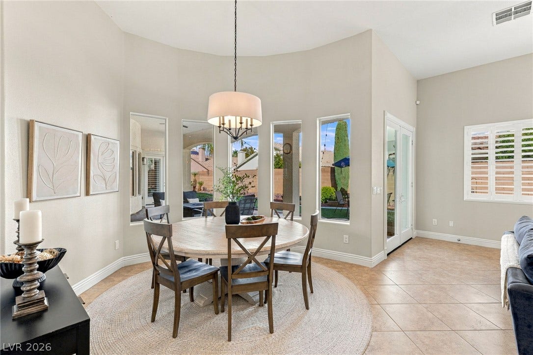 210 Torrey Morgan Way, Henderson, NV 89074 High ceilings and tall windows frame this sunlit dining area with tile flooring.