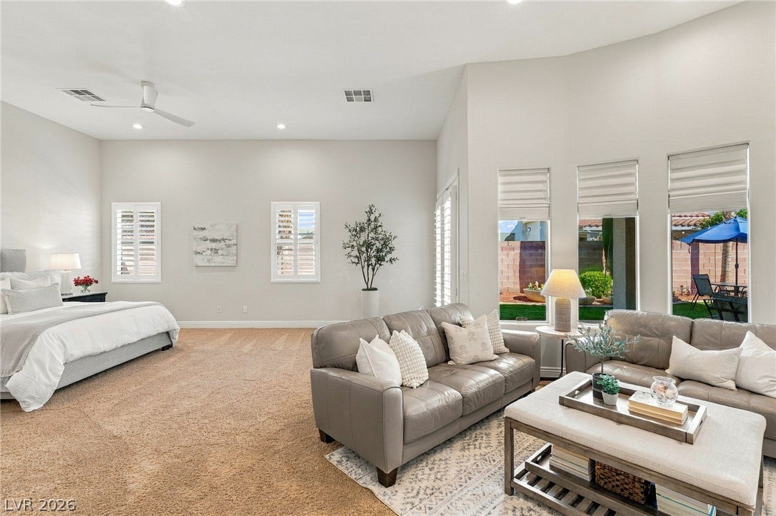 210 Torrey Morgan Way, Henderson, NV 89074 A spacious bedroom suite boasts plush carpeting and large windows overlooking the yard.