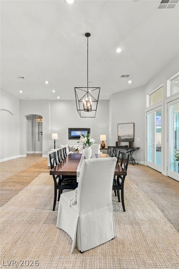 210 Torrey Morgan Way, Henderson, NV 89074 An open dining area features soaring ceilings and tall glass doors leading outside.
