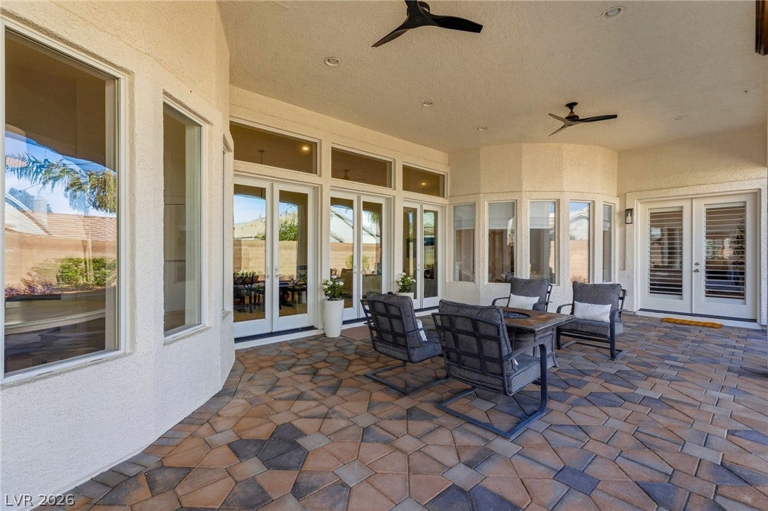 210 Torrey Morgan Way, Henderson, NV 89074 An inviting covered patio features extensive stone pavers and numerous windows overlooking the yard.
