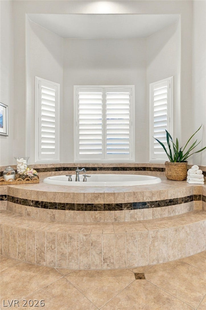 210 Torrey Morgan Way, Henderson, NV 89074 An elevated tile surround frames this deep soaking tub flanked by custom plantation shutters.