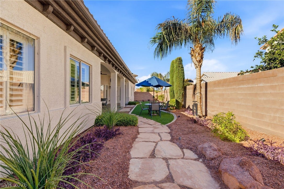 210 Torrey Morgan Way, Henderson, NV 89074 Flagstone pathways wind through a neatly landscaped side yard bordered by privacy fencing.