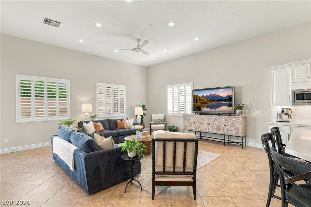 210 Torrey Morgan Way, Henderson, NV 89074 High ceilings and plantation shutters accent this spacious living area with ceramic tile flooring.