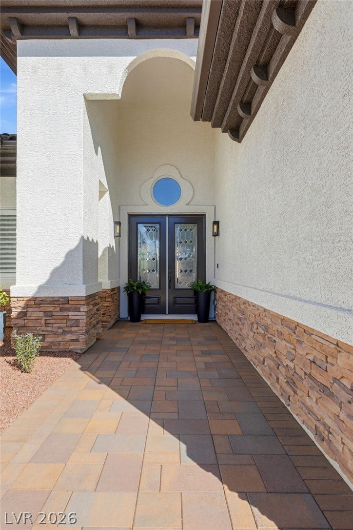 210 Torrey Morgan Way, Henderson, NV 89074 A grand arched entry with stone accents leads to decorative double doors.