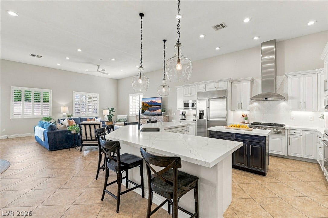 210 Torrey Morgan Way, Henderson, NV 89074 Gleaming stone countertops and a spacious breakfast bar anchor this airy open concept kitchen.