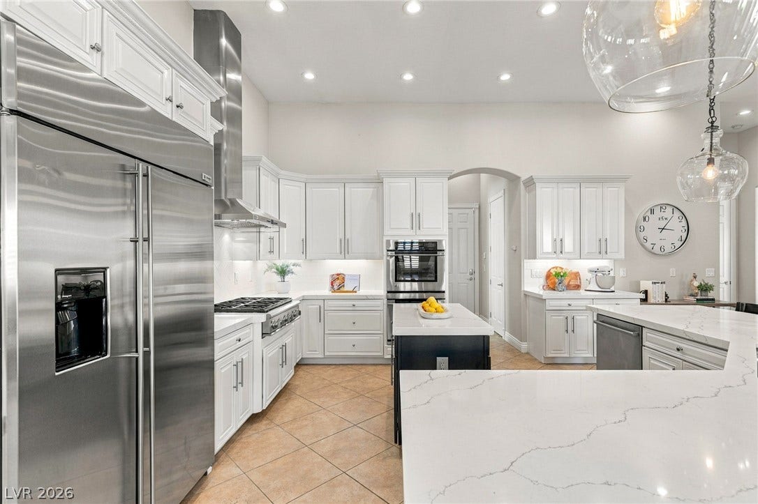 210 Torrey Morgan Way, Henderson, NV 89074 Gleaming stone countertops and custom cabinetry define this thoughtfully designed culinary workspace.
