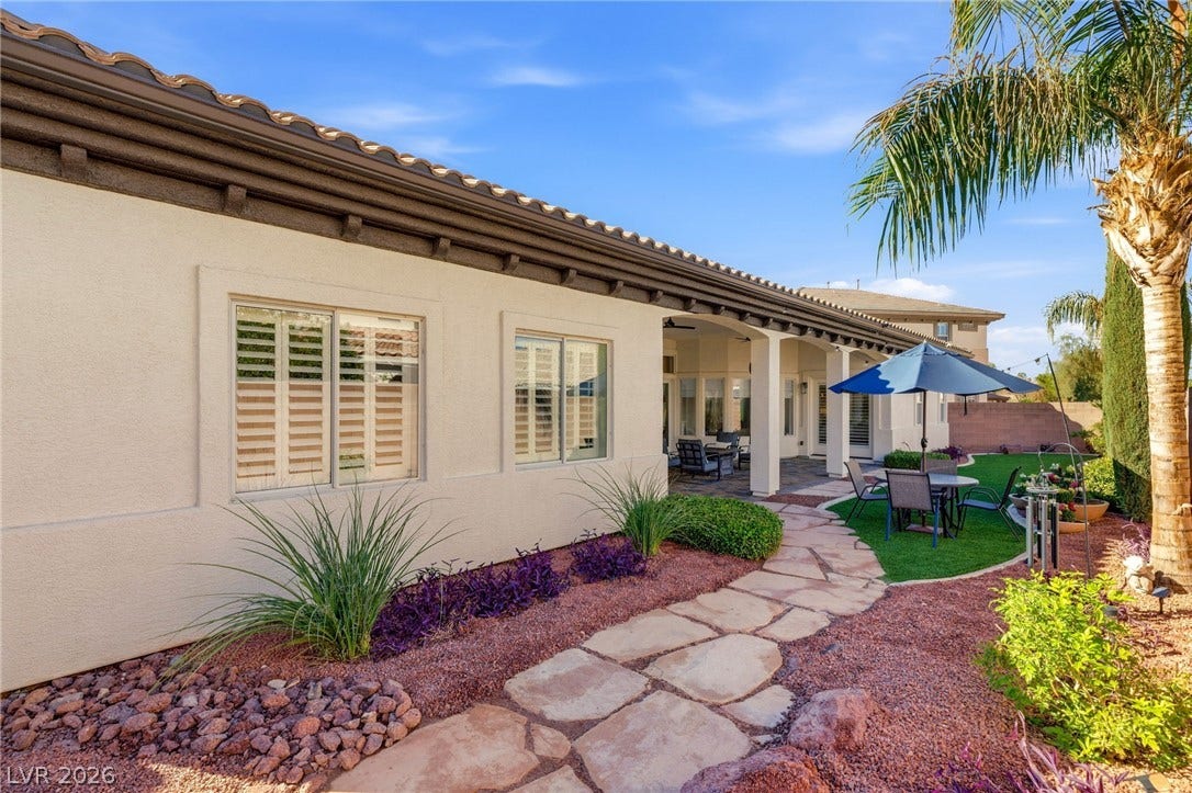 210 Torrey Morgan Way, Henderson, NV 89074 A winding flagstone path highlights the professionally landscaped backyard and stucco exterior.