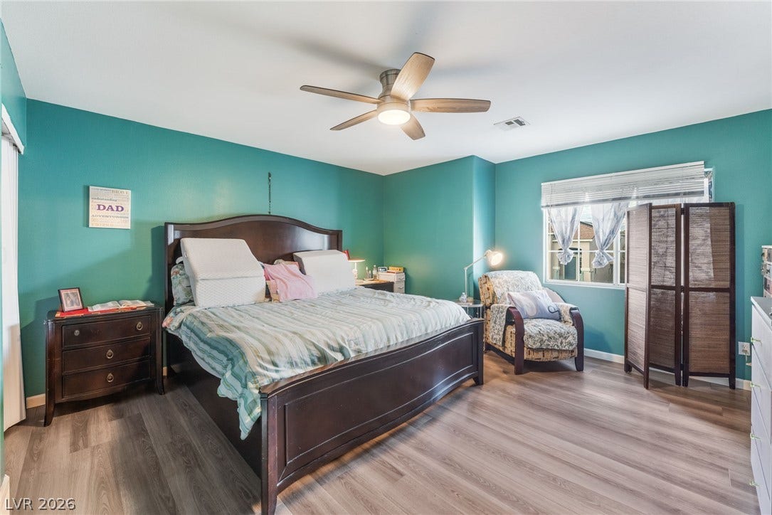 5348 Reardon Court, North Las Vegas, NV 89031 A spacious bedroom offers durable wood-look flooring and multiple windows providing natural light.