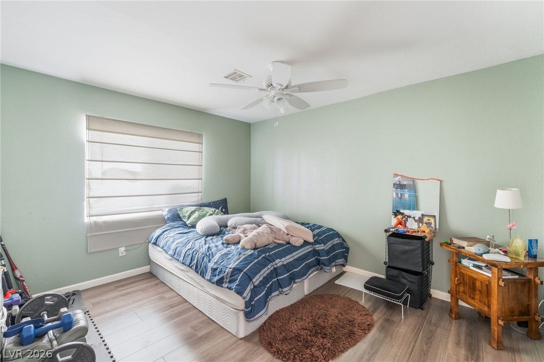 5348 Reardon Court, North Las Vegas, NV 89031 Smooth wood-look flooring and a wide window with integrated shades anchor this cozy bedroom.