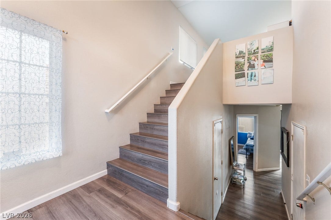 5348 Reardon Court, North Las Vegas, NV 89031 A staircase with wood steps ascends past high ceilings into a bright landing area.