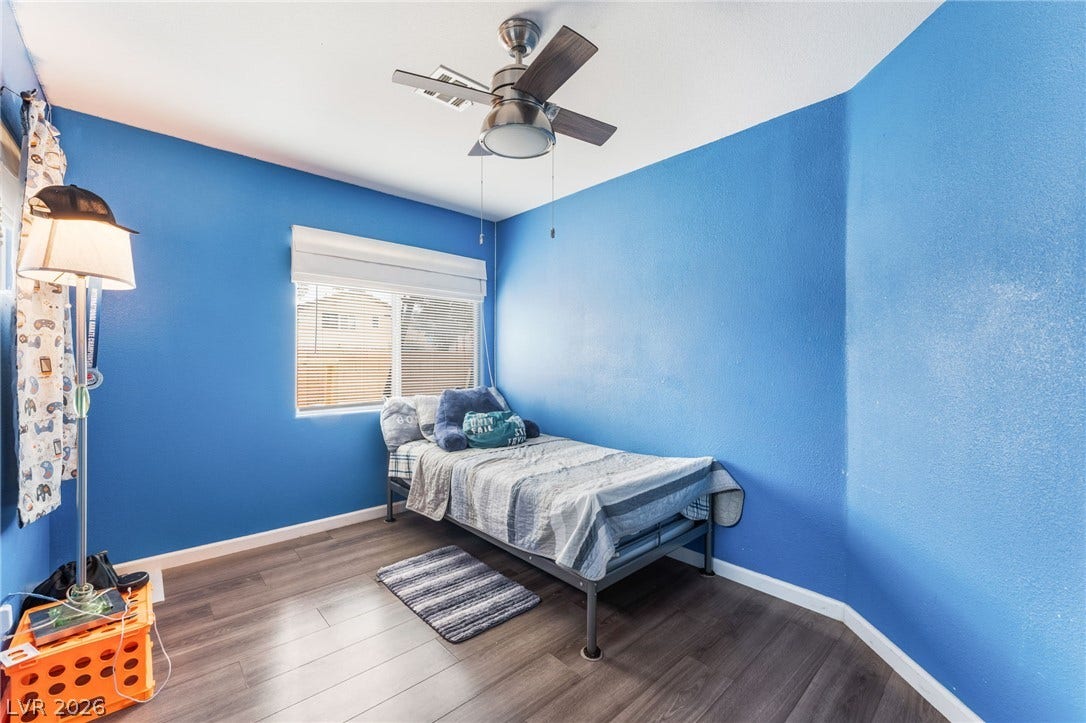 5348 Reardon Court, North Las Vegas, NV 89031 Rich wood plank flooring sets a warm foundation in this light-filled bedroom.