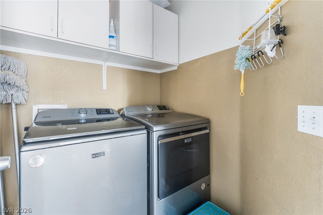5348 Reardon Court, North Las Vegas, NV 89031 A dedicated laundry space features built-in upper cabinetry over modern washing and drying machines.
