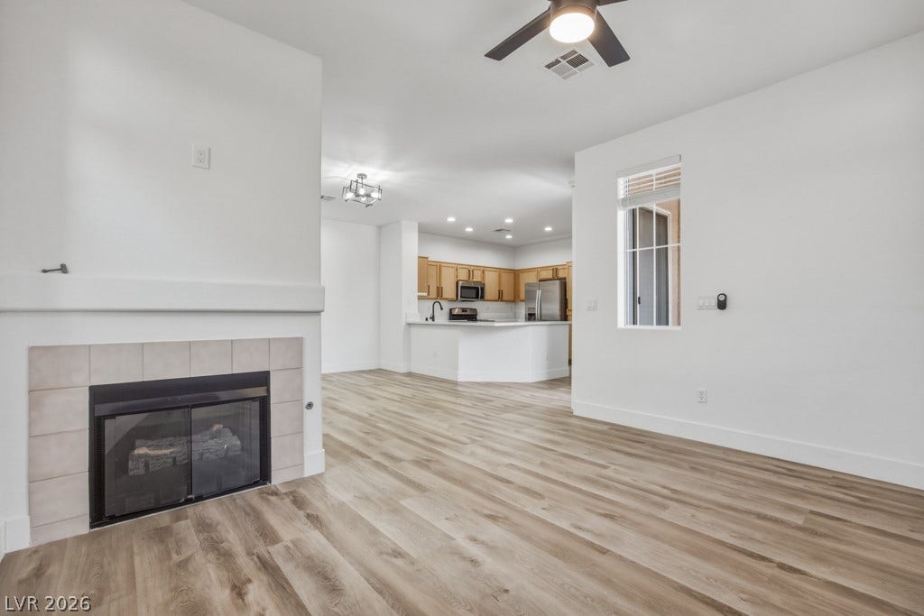 Actual Living Room with Ceiling Fan/Light Fixture and Gas Fireplace.