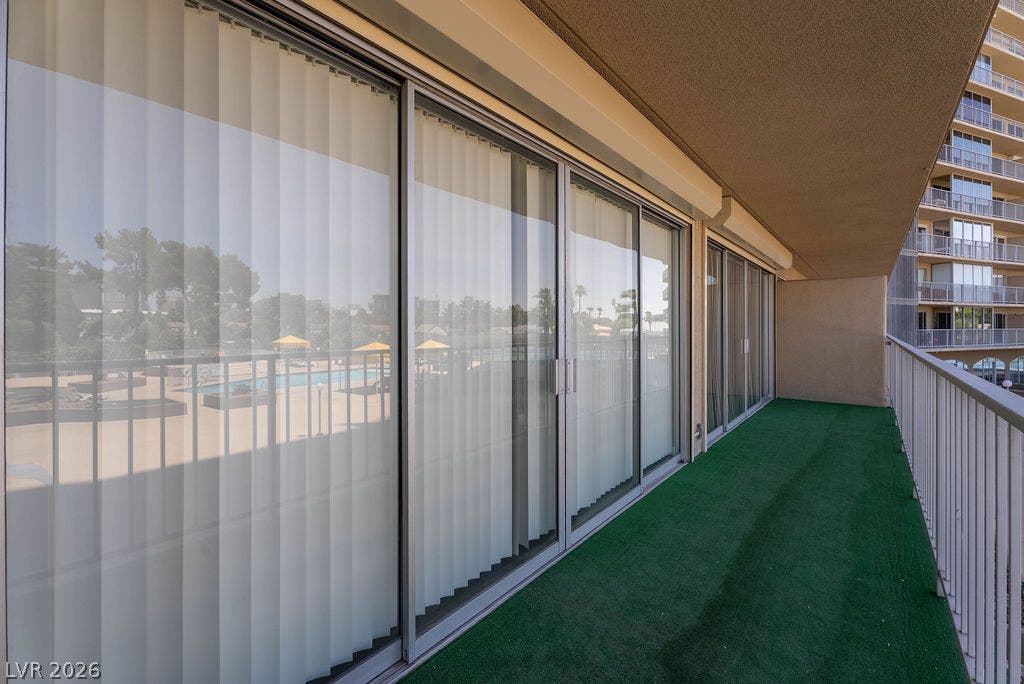 3111 Bel Air Drive, #3A, Las Vegas, NV 89109 Sliding glass doors open onto a private balcony finished with green outdoor carpeting.