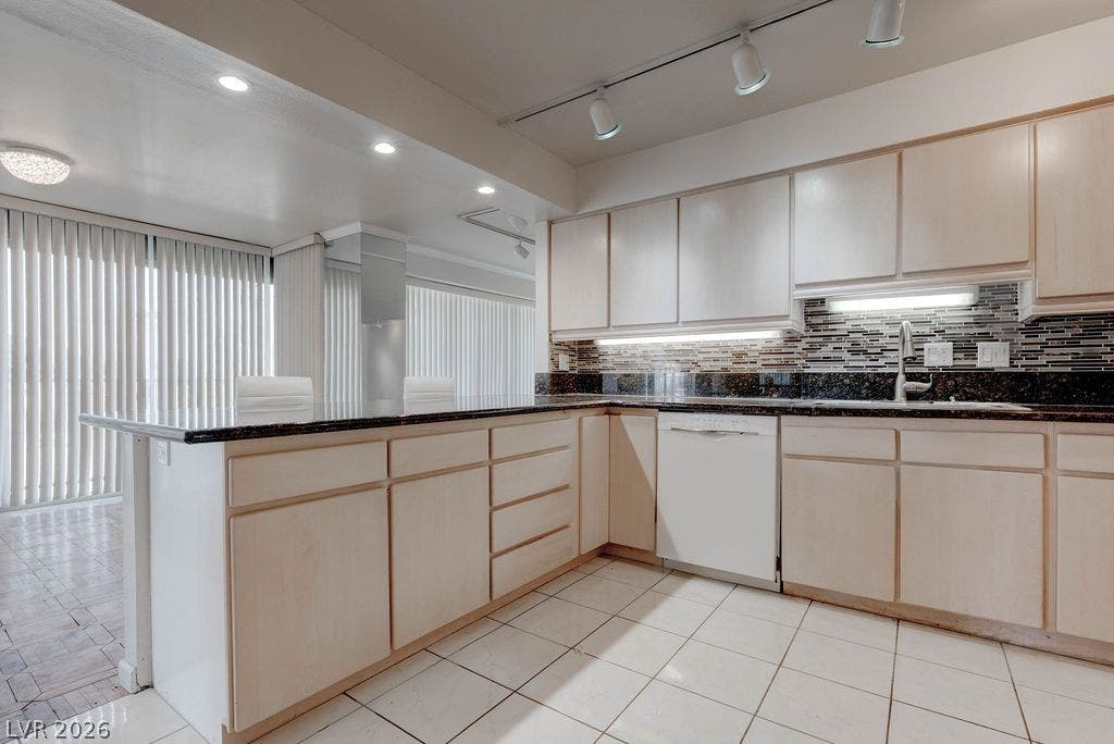 3111 Bel Air Drive, #3A, Las Vegas, NV 89109 Flat-panel wood cabinetry, dark countertops, and tile flooring define this highly functional workspace.