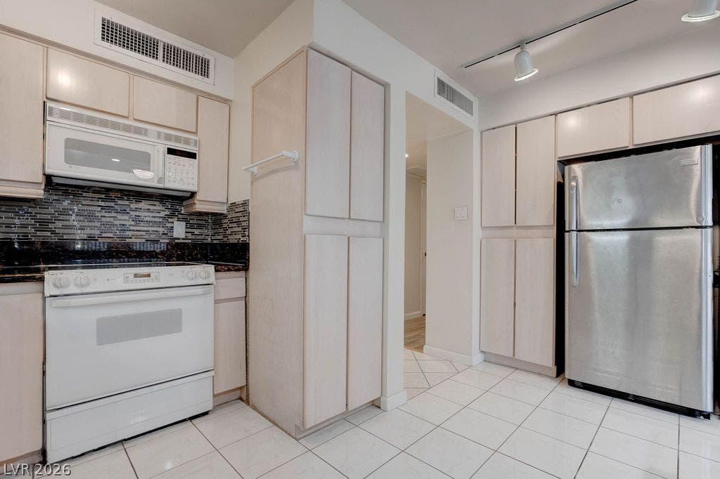 3111 Bel Air Drive, #3A, Las Vegas, NV 89109 Ample cabinetry and stone countertops accent this kitchen with tiled flooring.