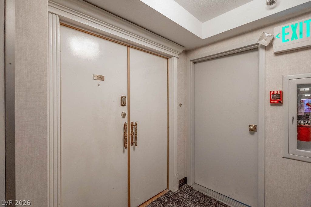 3111 Bel Air Drive, #3A, Las Vegas, NV 89109 Double entry doors framed by classic crown molding open to a carpeted hallway corridor.