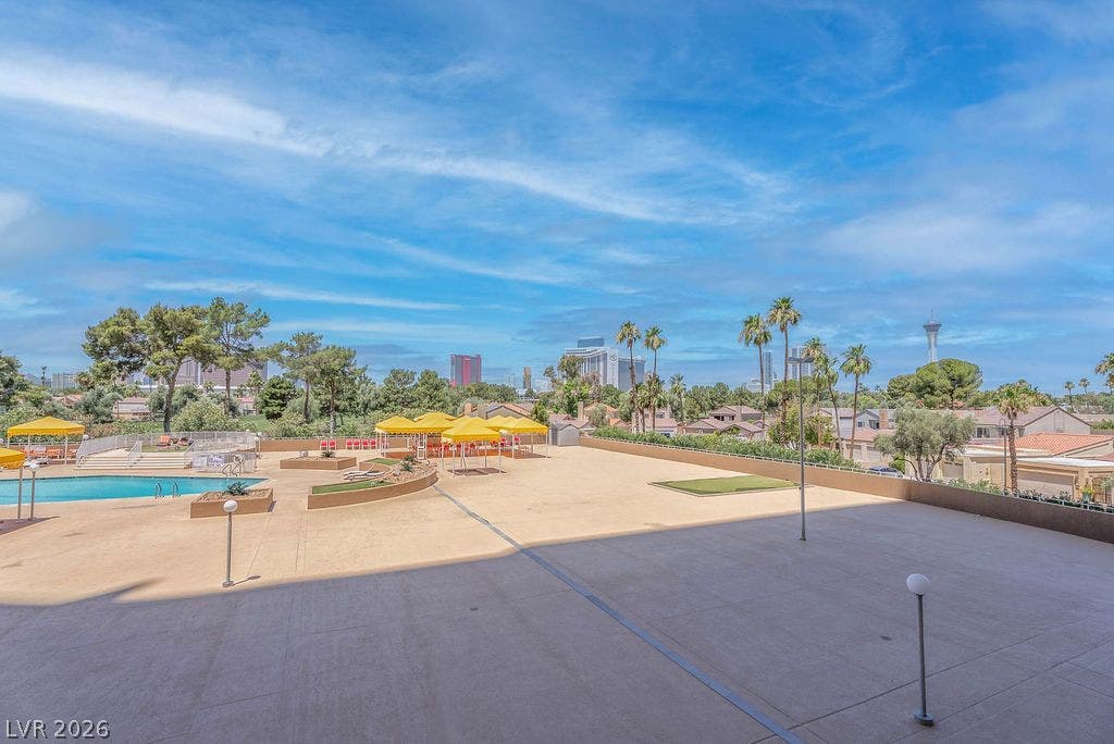 3111 Bel Air Drive, #3A, Las Vegas, NV 89109 An expansive concrete terrace overlooks the sparkling pool area and distant city skyline.