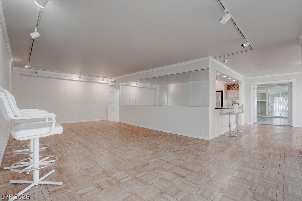 3111 Bel Air Drive, #3A, Las Vegas, NV 89109 Geometric patterned parquet floors anchor a spacious living room lined with custom track lighting.