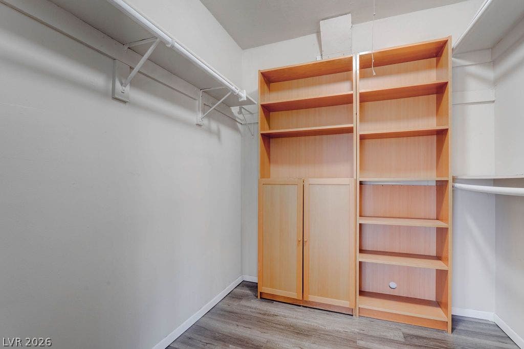 3111 Bel Air Drive, #3A, Las Vegas, NV 89109 Functional storage space includes open shelving and hanging rods above wood-plank flooring.