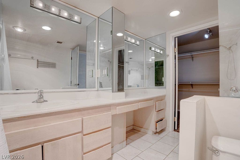 3111 Bel Air Drive, #3A, Las Vegas, NV 89109 Tiled flooring pairs with a long double vanity featuring integrated mirrors and recessed lighting.
