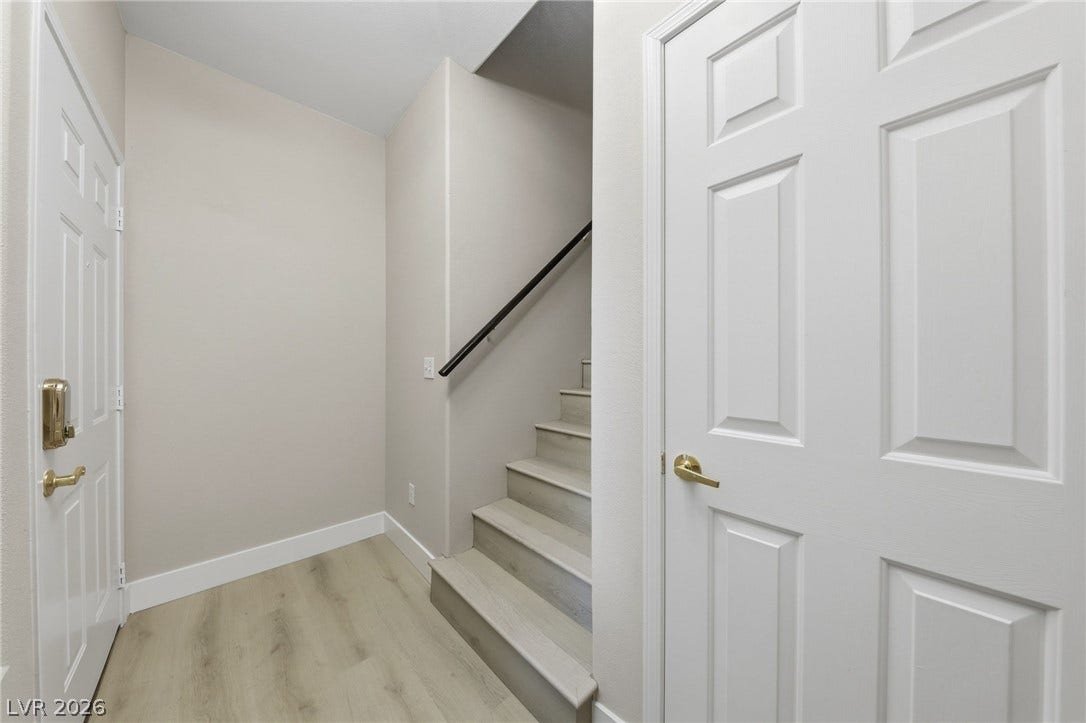104 Lemon Glaze Street, #204, Las Vegas, NV 89145 Smooth vinyl plank flooring complements a crisp, neutral hallway leading to carpet-free stairs.