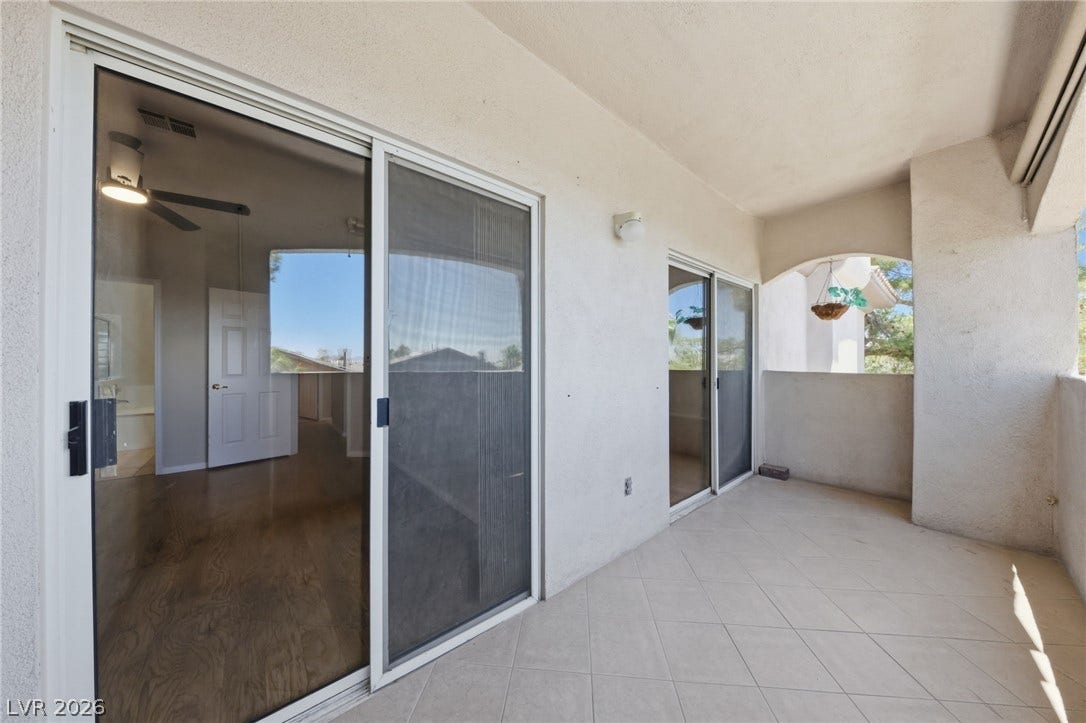 104 Lemon Glaze Street, #204, Las Vegas, NV 89145 A spacious covered balcony features tiled flooring and large sliding glass doors.