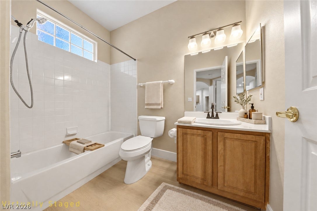 104 Lemon Glaze Street, #204, Las Vegas, NV 89145 A well-appointed vanity cabinet sits adjacent to a classic tub with tiled surround.
