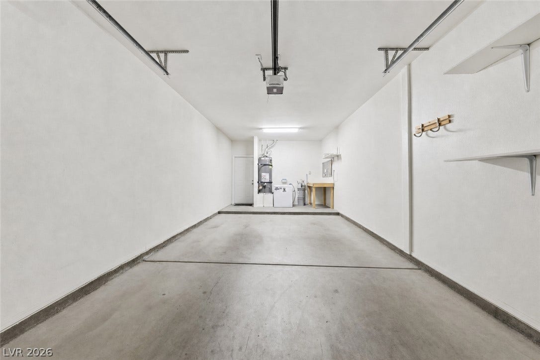 104 Lemon Glaze Street, #204, Las Vegas, NV 89145 An attached garage features concrete flooring, built-in shelving, and dedicated laundry utility hookups.