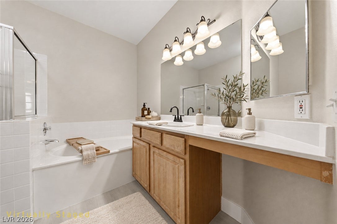 104 Lemon Glaze Street, #204, Las Vegas, NV 89145 A spacious double vanity and deep soaking tub define this classic primary bathroom layout.