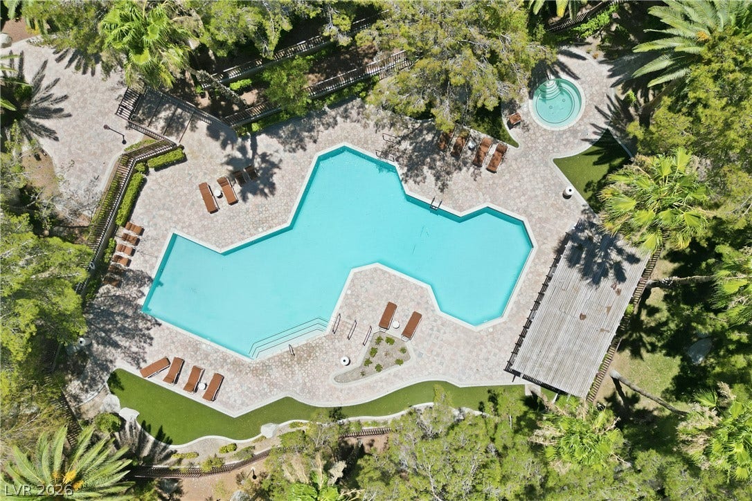 104 Lemon Glaze Street, #204, Las Vegas, NV 89145 Lush tropical landscaping surrounds a sparkling pool and circular spa with stone decking.