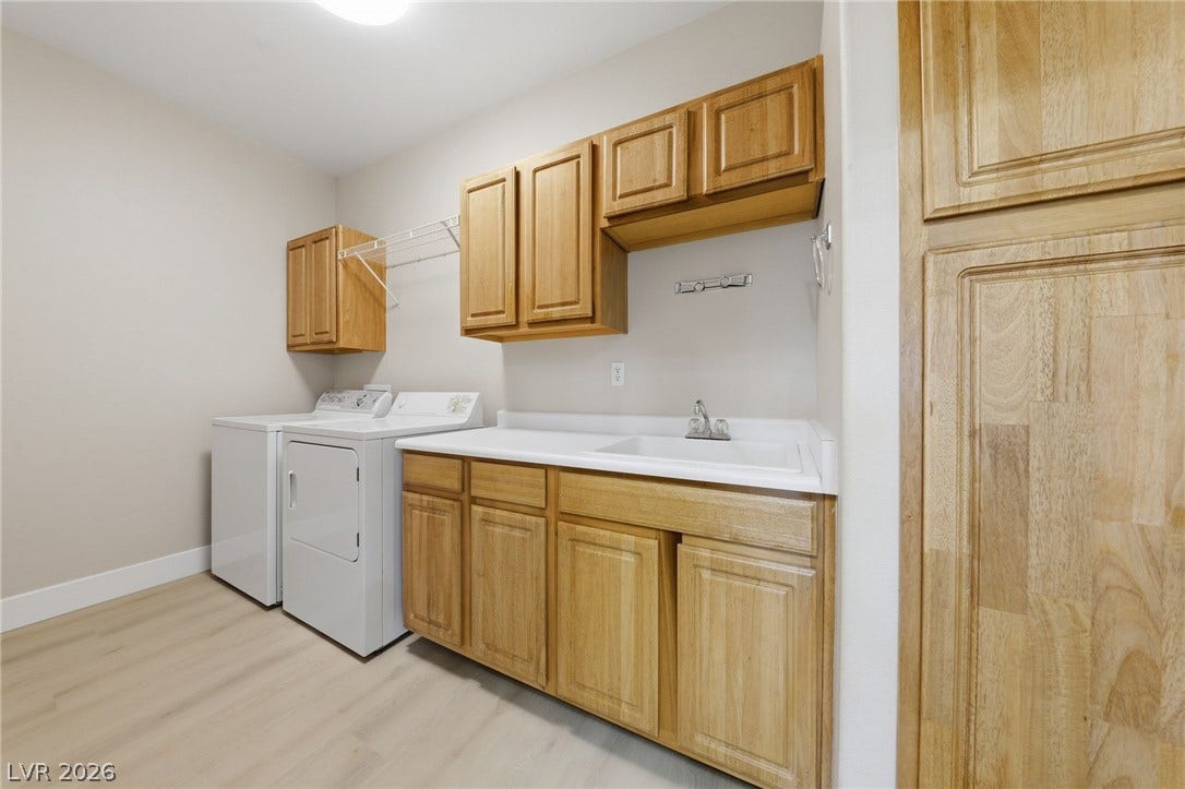 104 Lemon Glaze Street, #204, Las Vegas, NV 89145 Ample wooden cabinetry and a built-in sink highlight this highly functional dedicated laundry space.