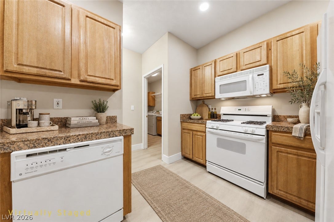 104 Lemon Glaze Street, #204, Las Vegas, NV 89145 Warm wood cabinetry and granite countertops frame this efficient kitchen layout.