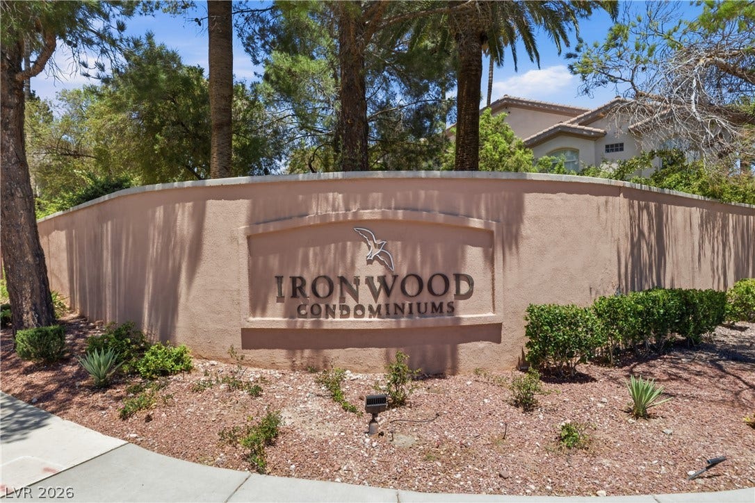 104 Lemon Glaze Street, #204, Las Vegas, NV 89145 Mature palms and desert landscaping frame the stucco monument wall welcoming residents home.