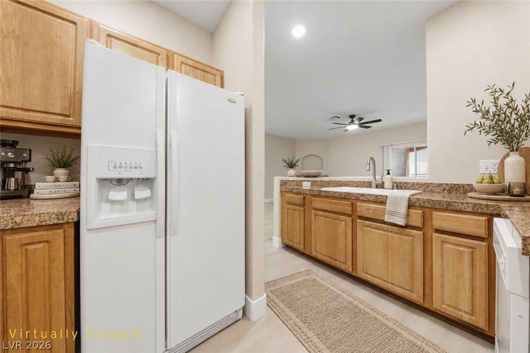 104 Lemon Glaze Street, #204, Las Vegas, NV 89145 Warm wood cabinetry and granite counters define this inviting, open-concept kitchen.