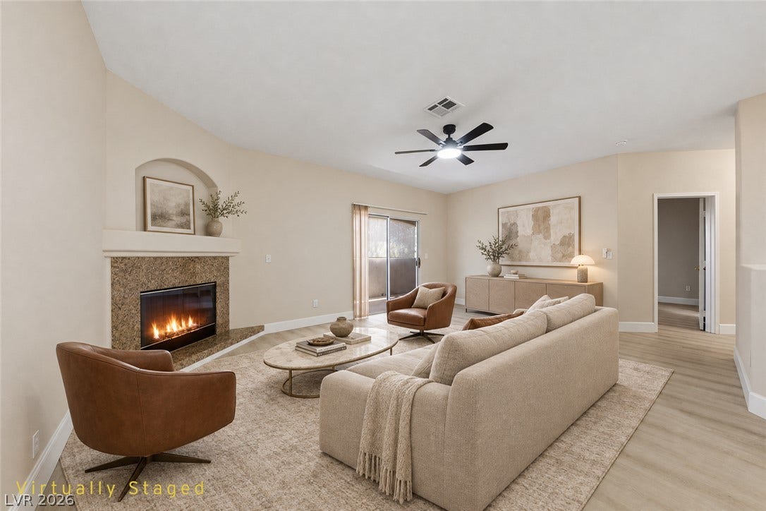 104 Lemon Glaze Street, #204, Las Vegas, NV 89145 A classic fireplace with stone surround anchors this comfortable living area featuring sliding door access.
