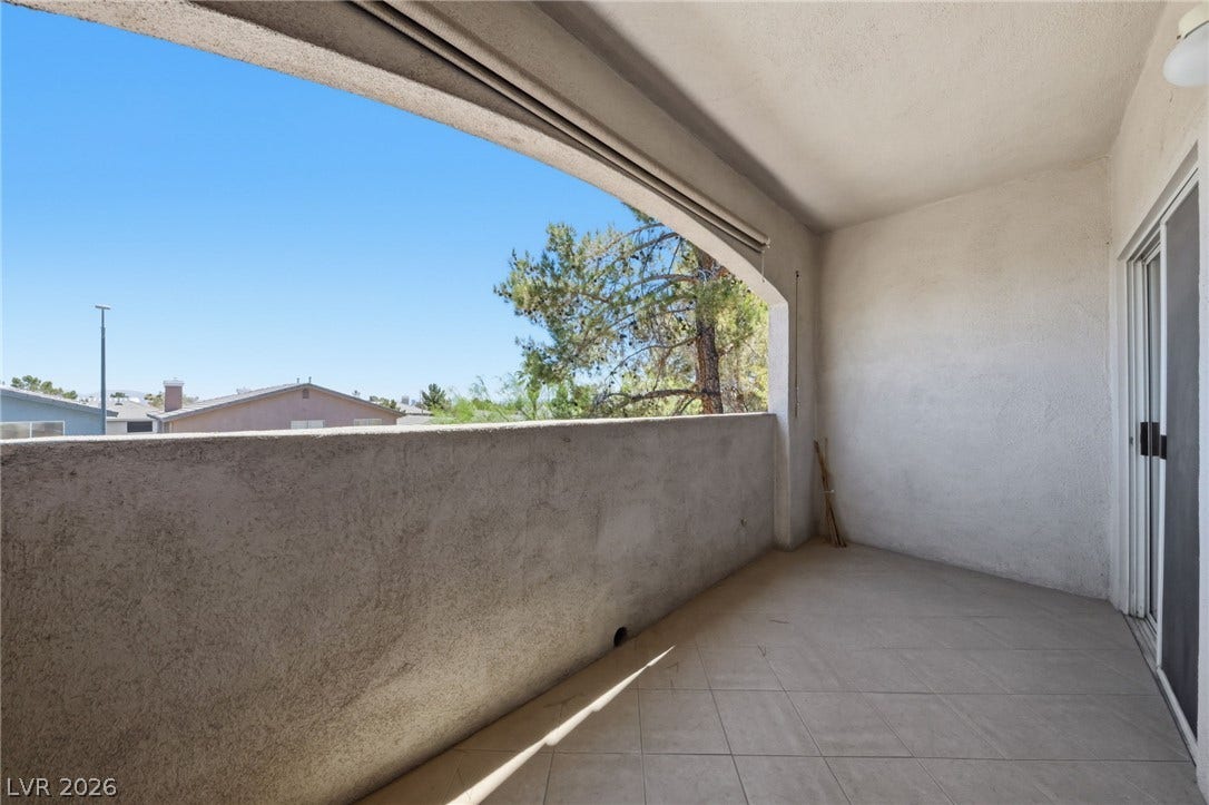 104 Lemon Glaze Street, #204, Las Vegas, NV 89145 Tiled private balcony features covered overhead shelter and sliding glass door access.