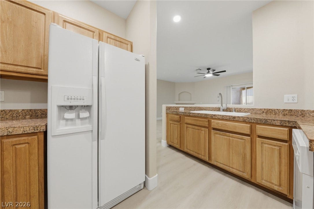104 Lemon Glaze Street, #204, Las Vegas, NV 89145 Warm wood cabinetry paired with stone countertops defines this open, functional kitchen workspace.