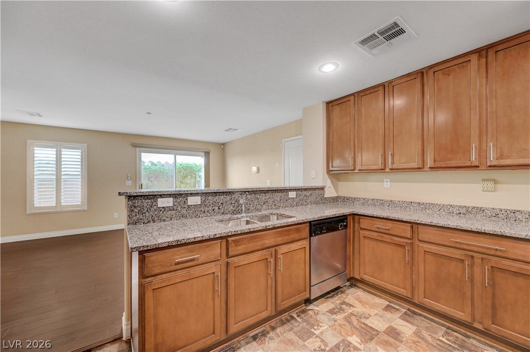 2088 Artistic Flair Walk, Henderson, NV 89044 Granite countertops and rich wood cabinetry anchor this functional, open-concept kitchen.