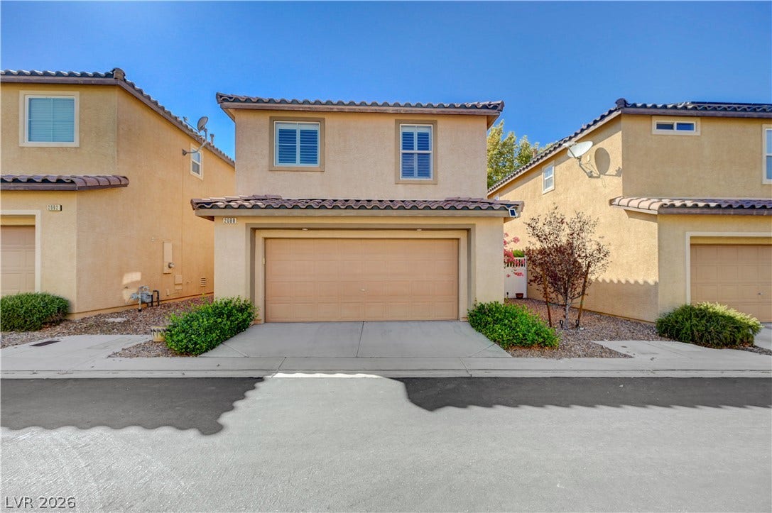 2088 Artistic Flair Walk, Henderson, NV 89044 Two-story stucco home features a Spanish tile roof and an attached two-car garage.