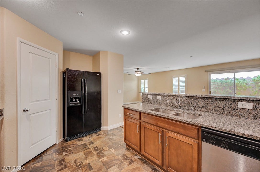 2088 Artistic Flair Walk, Henderson, NV 89044 Granite countertops pair beautifully with natural wood cabinetry in this open kitchen design.