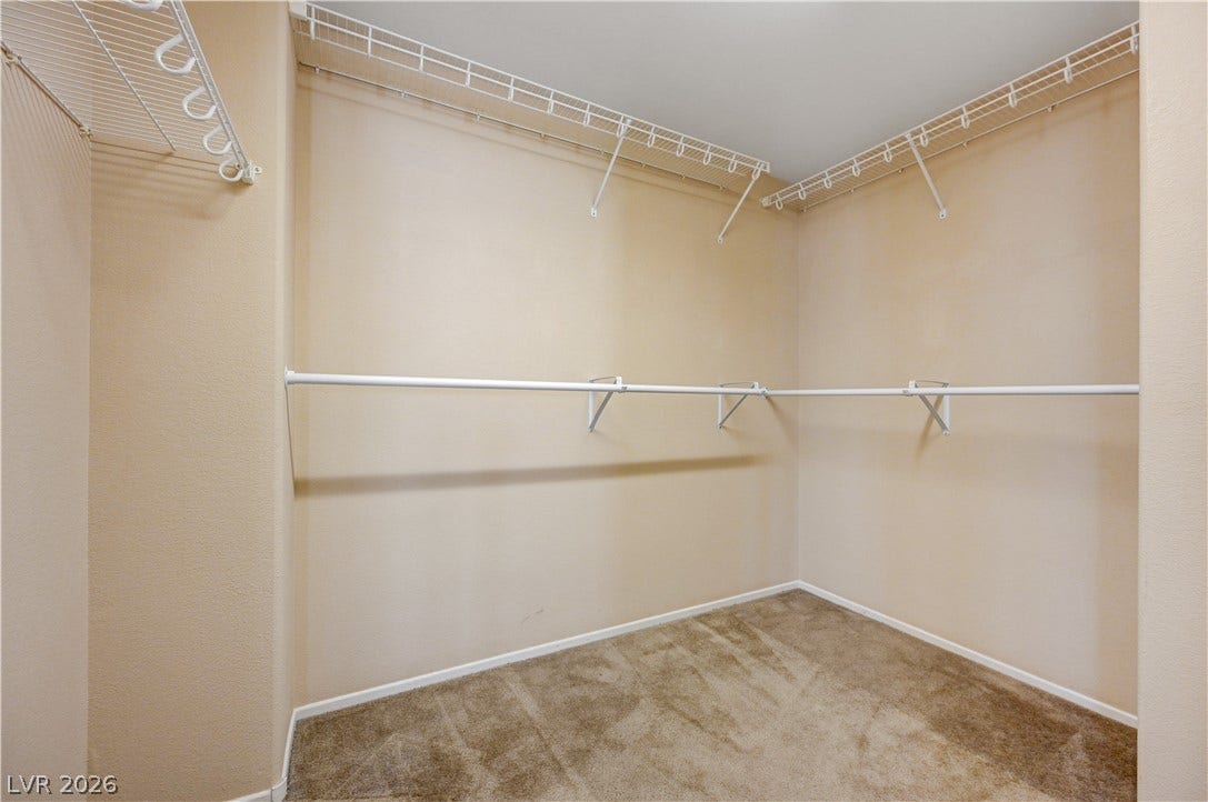 2088 Artistic Flair Walk, Henderson, NV 89044 A spacious walk-in closet features built-in wire shelving and hanging rods over carpeted flooring.