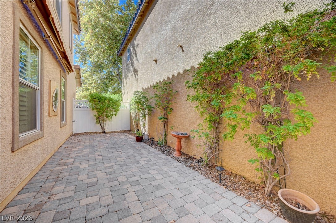 2088 Artistic Flair Walk, Henderson, NV 89044 A secluded stone paver patio offers a peaceful outdoor retreat between stucco walls.
