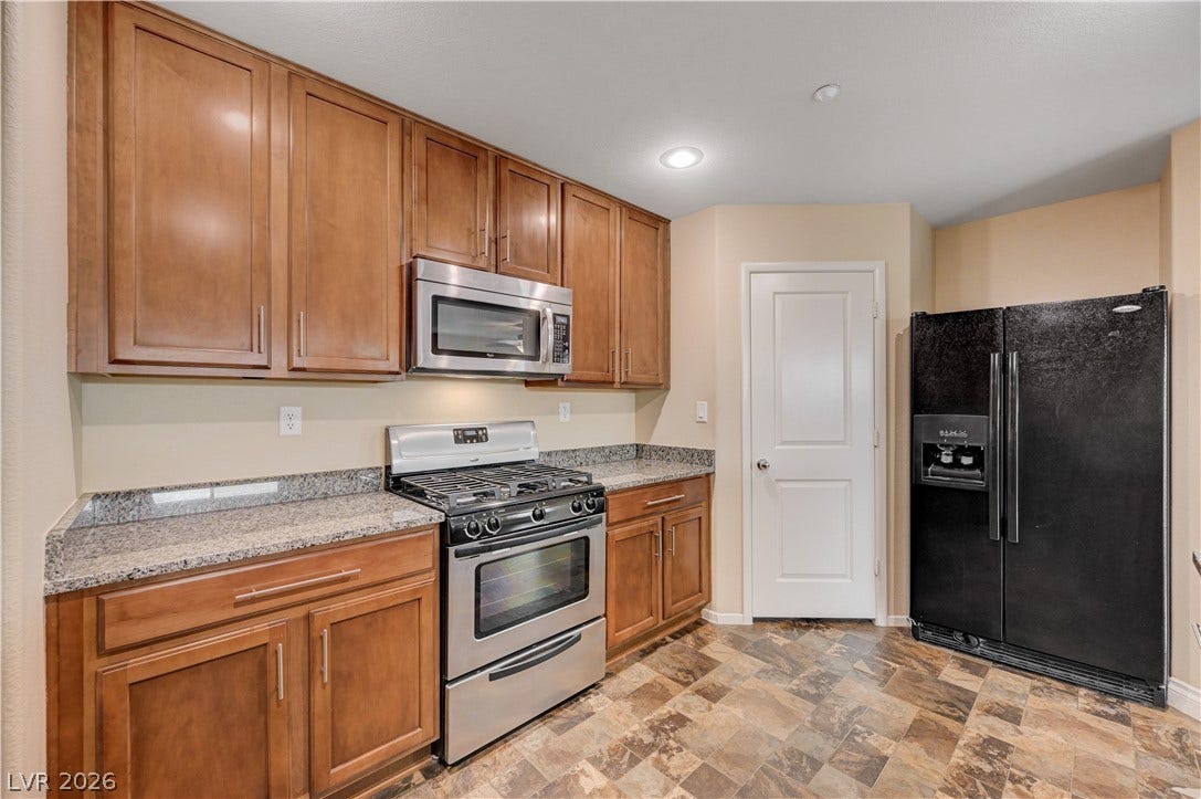 2088 Artistic Flair Walk, Henderson, NV 89044 Warm wood cabinetry and granite countertops create an inviting kitchen space.