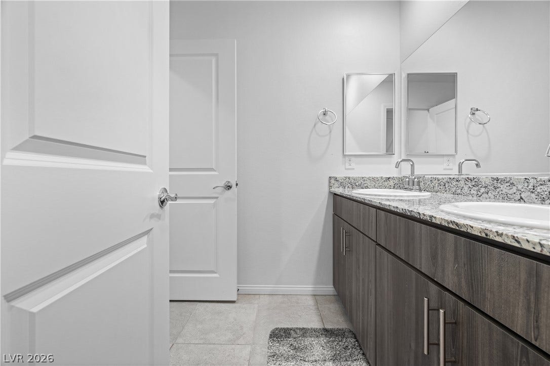 4429 Ginger Hills Avenue, Las Vegas, NV 89141 Granite counters and dual sinks elevate this modern bathroom layout.