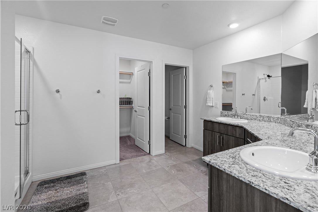 4429 Ginger Hills Avenue, Las Vegas, NV 89141 Gleaming stone countertops and a spacious tile floor define this modern bathroom layout.