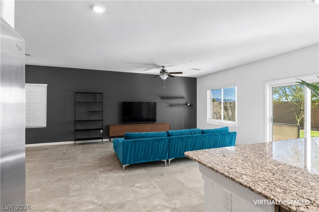 4429 Ginger Hills Avenue, Las Vegas, NV 89141 Granite counters overlook a tiled open-concept living area brightened by sliding glass doors.