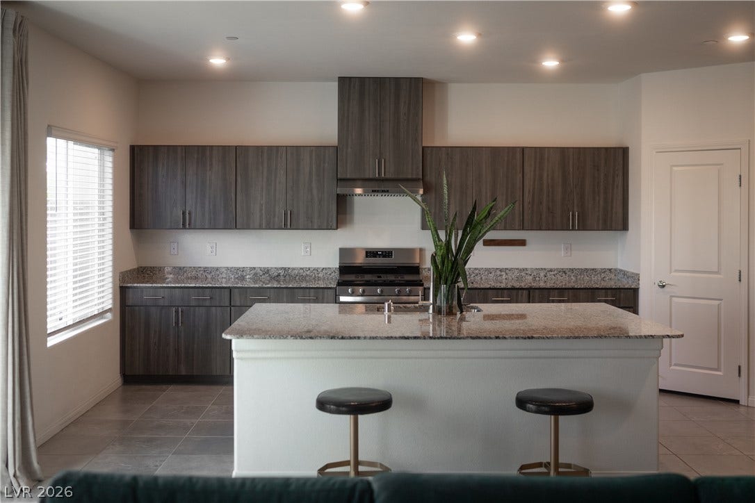 4429 Ginger Hills Avenue, Las Vegas, NV 89141 Polished quartz countertops pair elegantly with grey cabinetry and a functional central island.