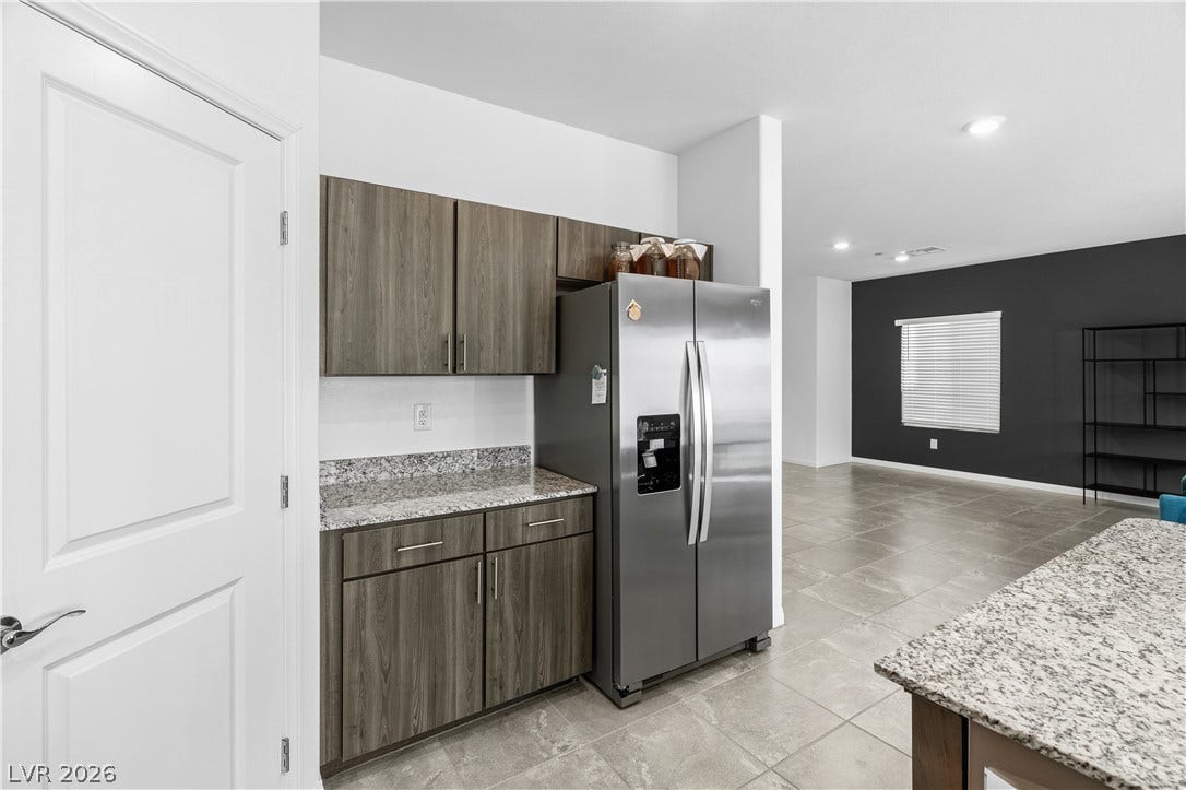 4429 Ginger Hills Avenue, Las Vegas, NV 89141 Granite countertops and contemporary cabinetry define this functional kitchen area opening to the living space.